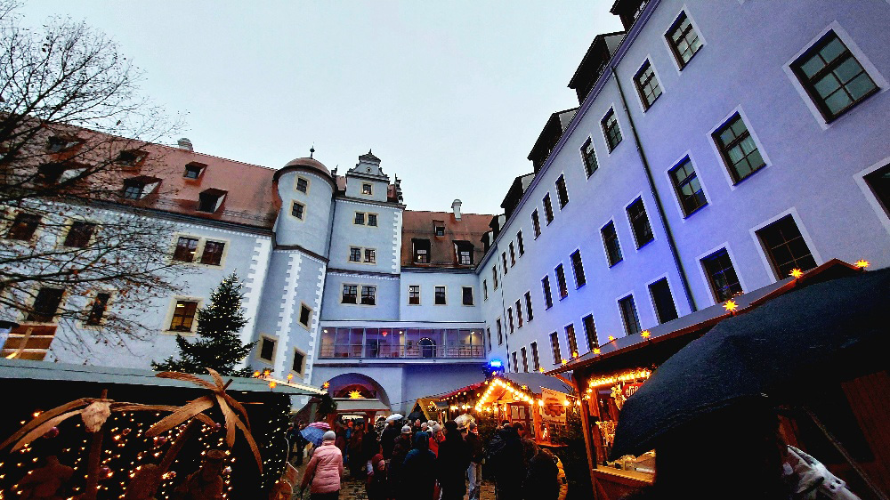 Der Weihnachtsmarkt im festlich geschmückten Innenhof erstrahlt im Lichterglanz.